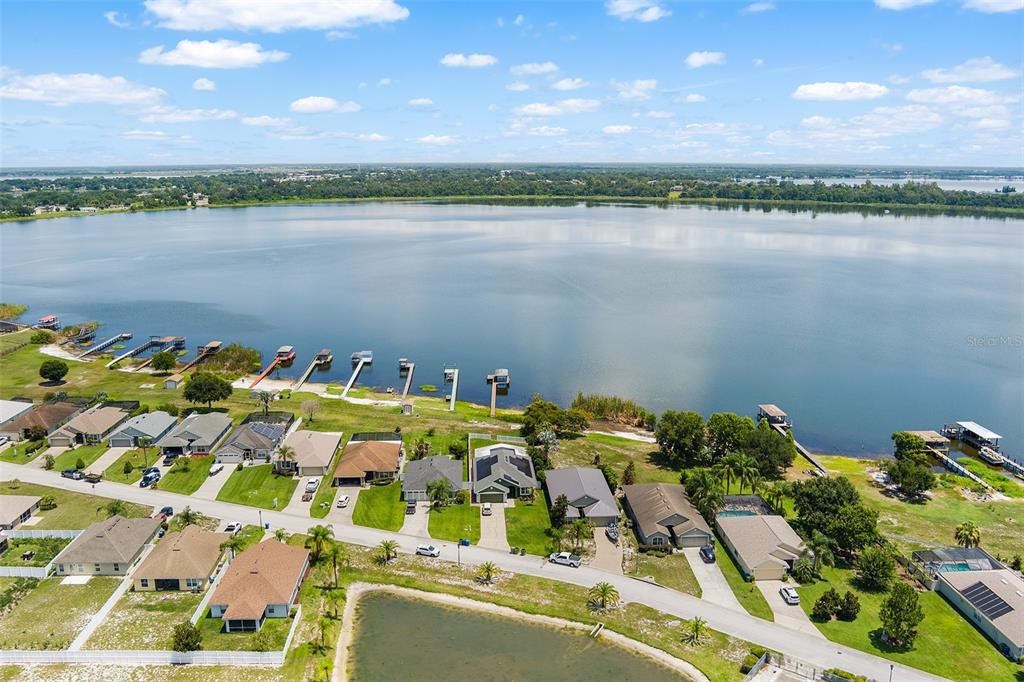 An aerial view shows a residential neighborhood situated along the shore of a large lake — 4123 ISLAND LAKES DRIVE, WINTER HAVEN, FL