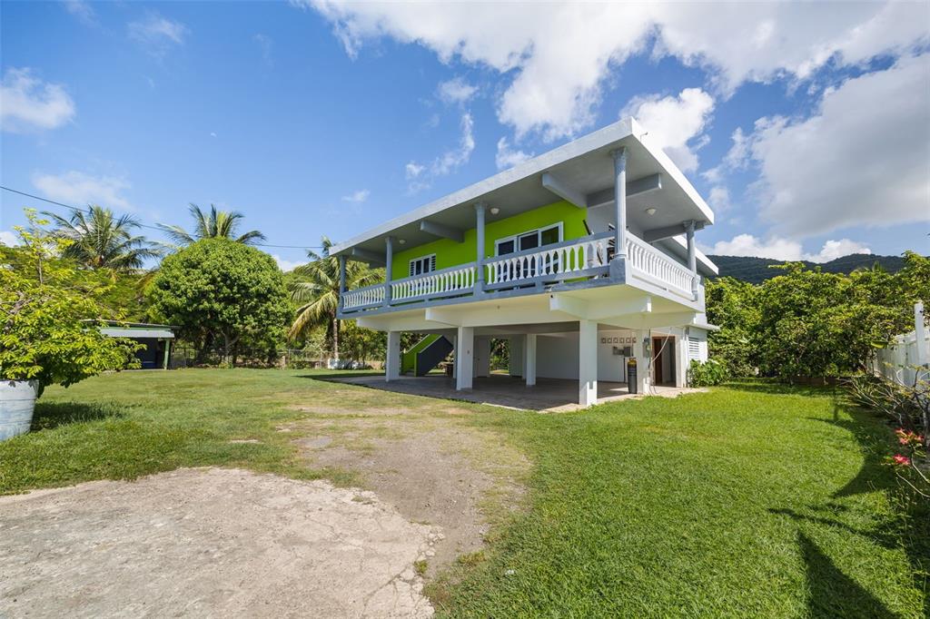 A two-story house with a lime green exterior, a wrap-around balcony, and an open ground level — CARR. 3 BO. GUARDARRAYA SECTOR COOPERATIVO UNIT KM 113.3, PATILLAS, PR