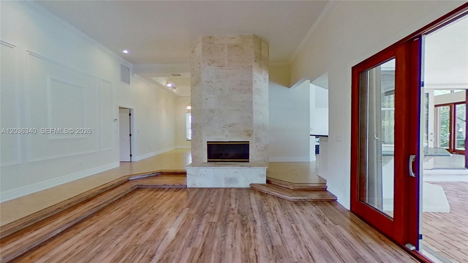 A living room features a central stone fireplace, wood flooring, and a sunken seating area — 405 Sabal Way, Weston FL 33326, WESTON, FL