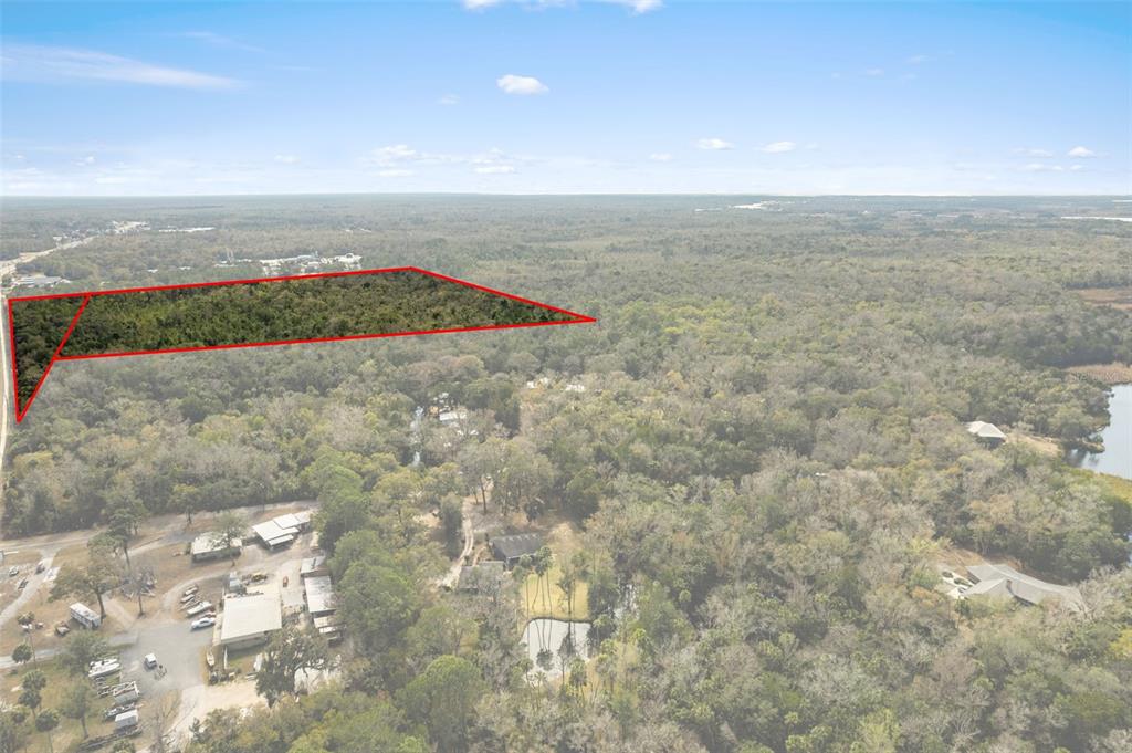 An aerial view shows a wooded plot of land outlined in red — 2872 S SUNCOAST BOULEVARD, HOMOSASSA, FL