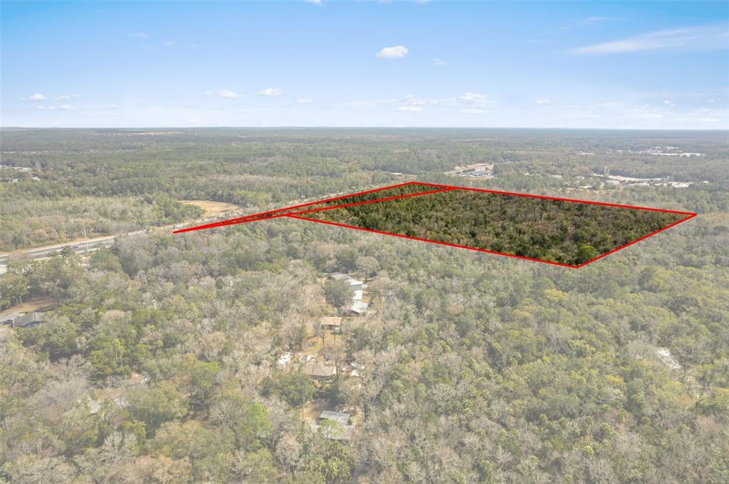 An aerial view shows a rectangular plot of land outlined in red amidst a forest — 2872 S SUNCOAST BOULEVARD, HOMOSASSA, FL