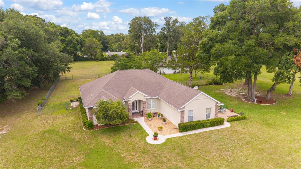 An aerial view of a single-story house with a brown roof surrounded by green lawns — 435 NE 155TH STREET ROAD, CITRA, FL