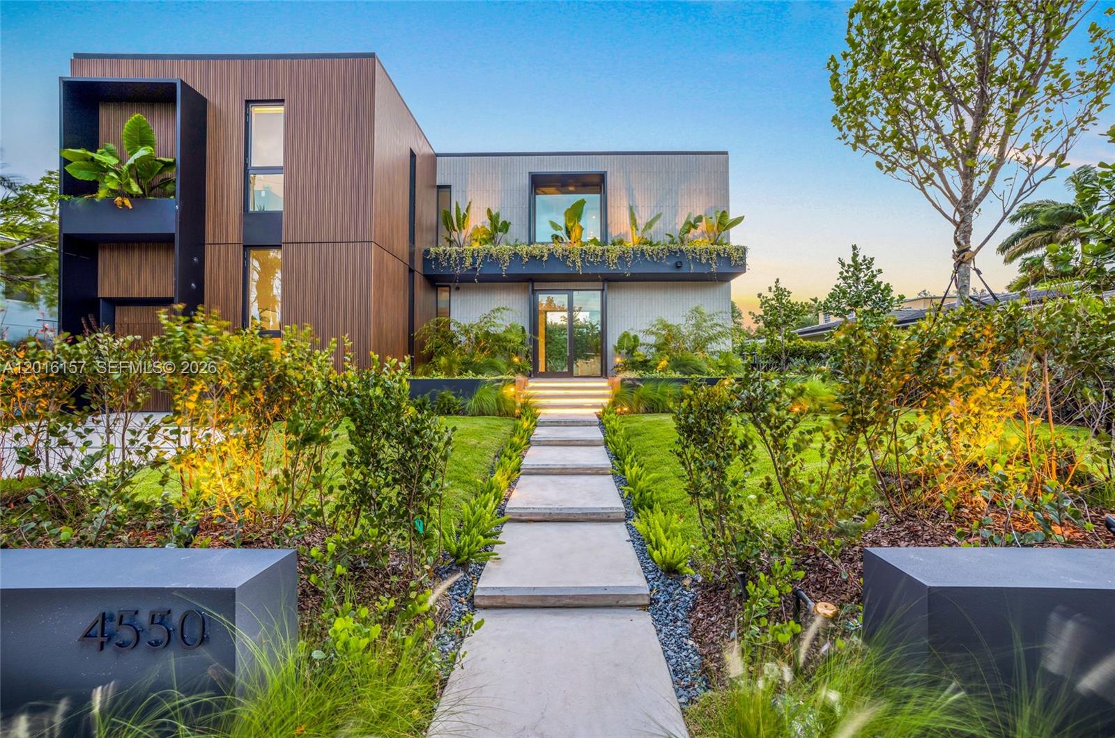 A modern two-story house features a concrete walkway leading to a glass front entrance — 4550 N Jefferson Ave, Miami Beach FL 33140, MIAMI BEACH, FL
