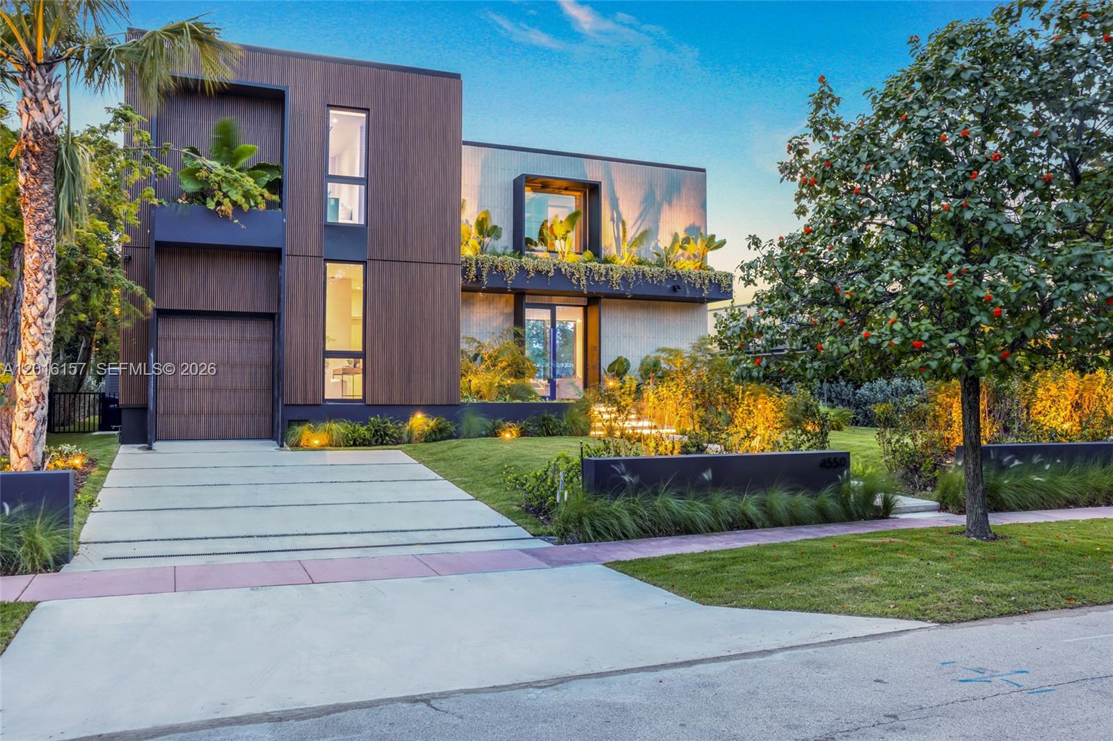A modern two-story house features vertical wood-slat siding, large windows, and lush landscaping — 4550 N Jefferson Ave, Miami Beach FL 33140, MIAMI BEACH, FL