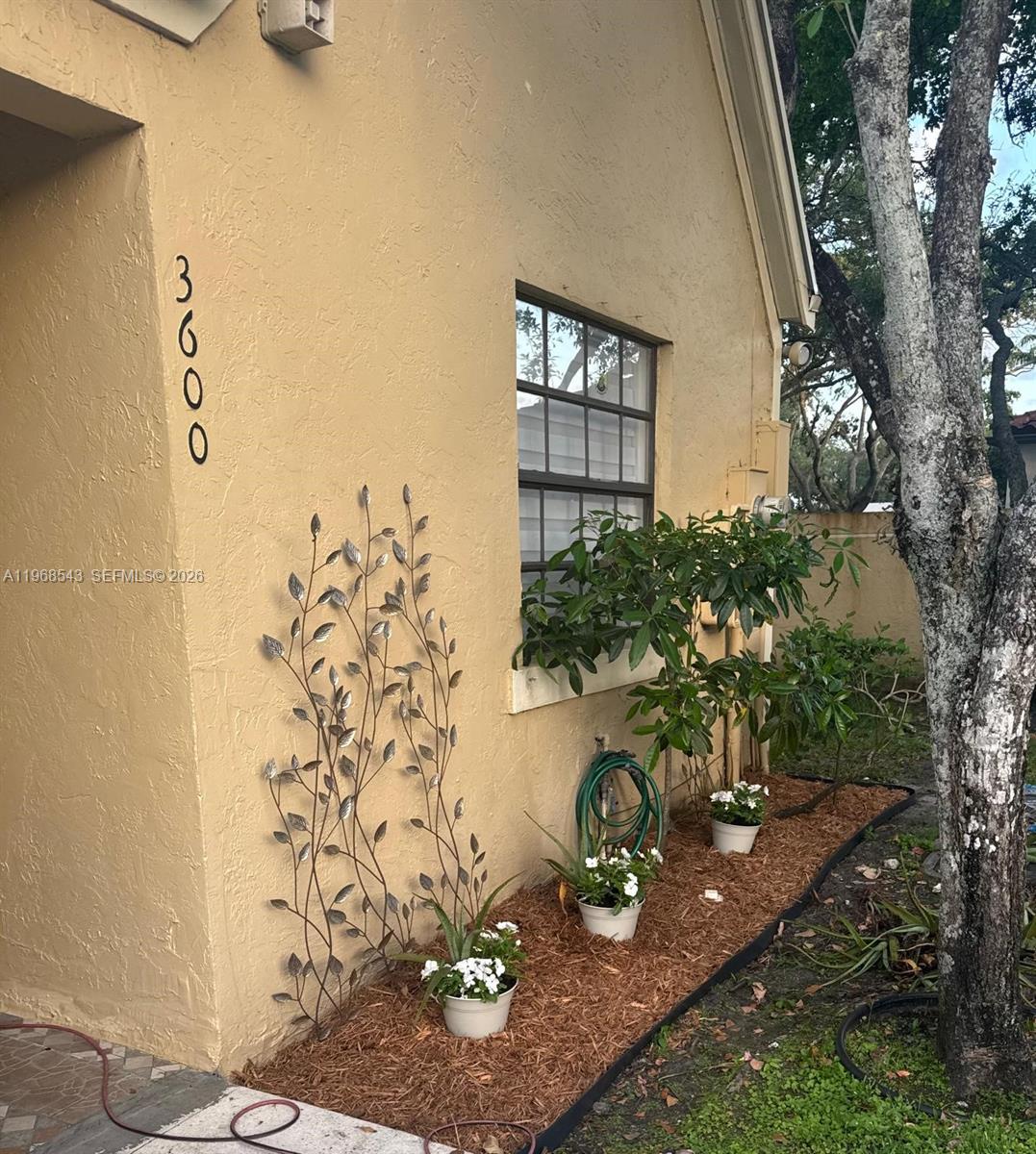 The exterior of a tan stucco house features a vertical address number and metal trellis — 3600 NW 83rd Ln, Sunrise FL 33351, SUNRISE, FL