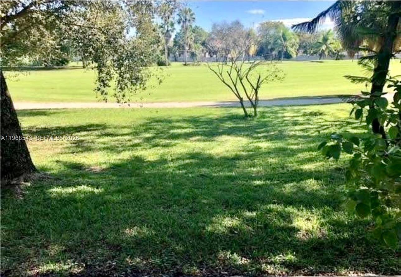 A grassy yard overlooks a golf course with trees and a path in the distance — 3600 NW 83rd Ln, Sunrise FL 33351, SUNRISE, FL