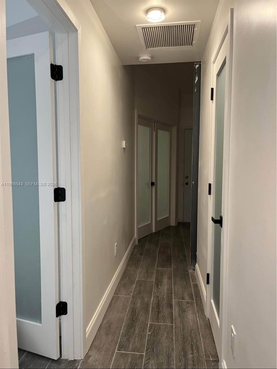 A narrow hallway features gray wood-look tile flooring and white doors with frosted glass panels — 3600 NW 83rd Ln, Sunrise FL 33351, SUNRISE, FL