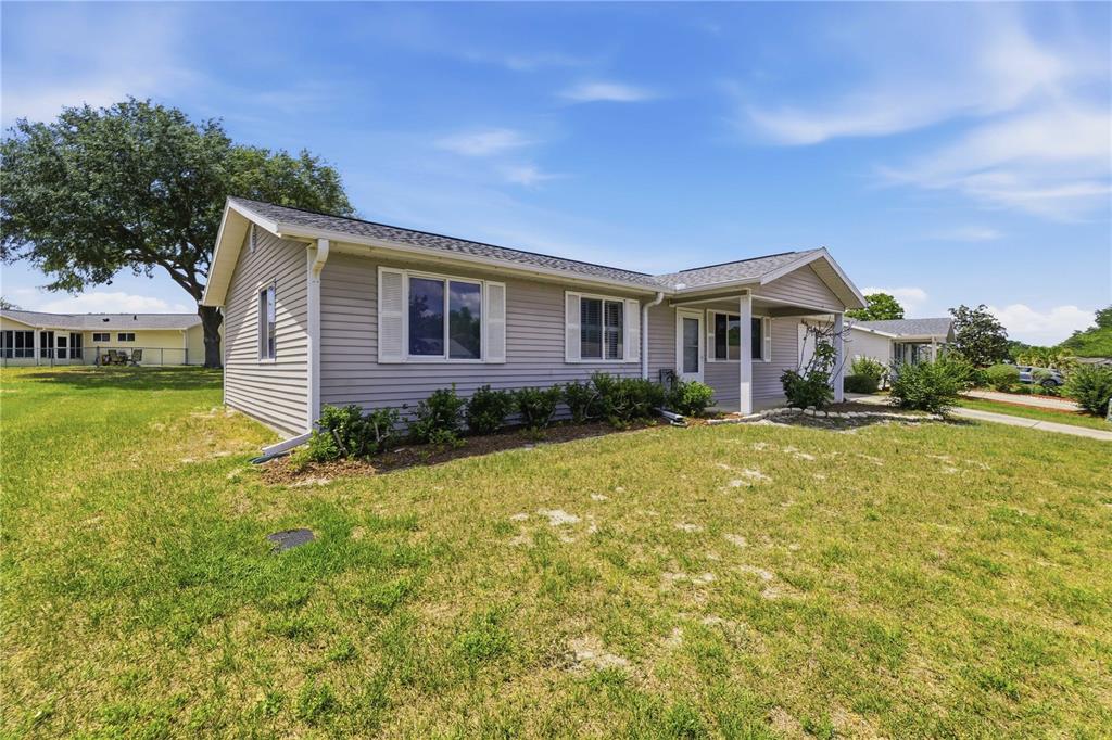 A single-story house with light gray siding and a covered front porch sits on grass — 10986 SW 83RD AVENUE, OCALA, FL