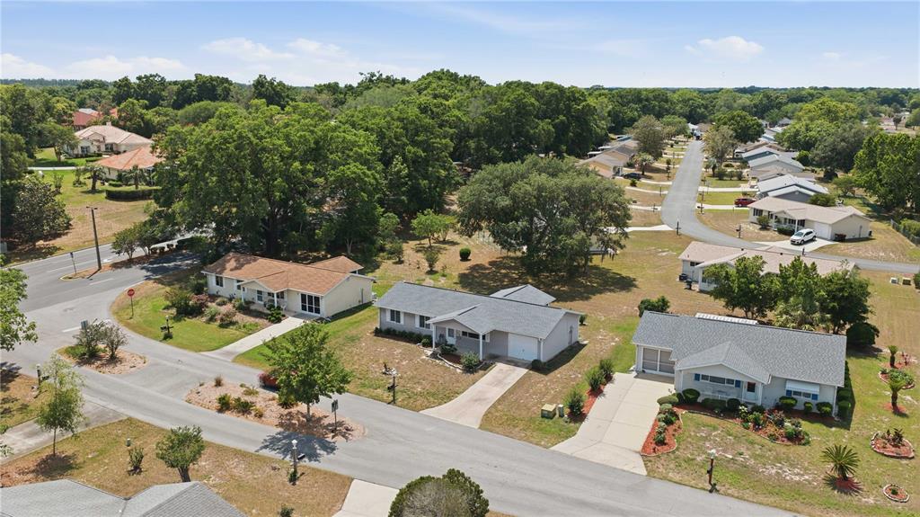 An aerial view shows several single-story houses with driveways and lawns in a suburban neighborhood — 10986 SW 83RD AVENUE, OCALA, FL