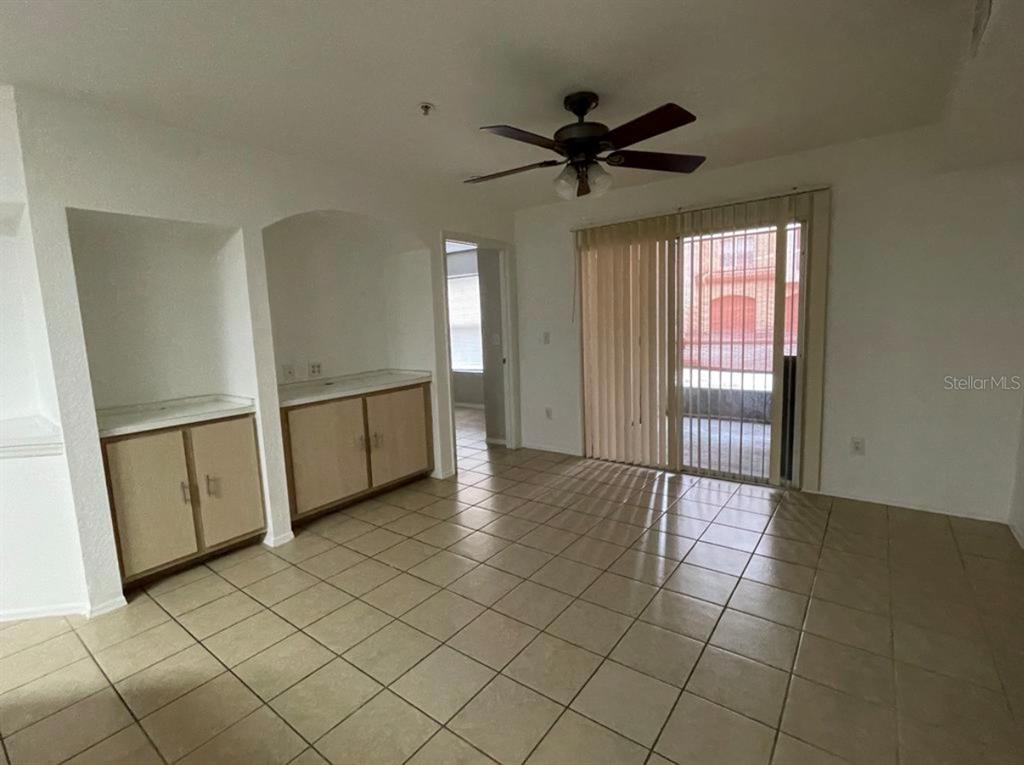 An interior room with tile flooring, built-in cabinets, a ceiling fan, and sliding glass doors — 827 CAMARGO WAY UNIT 112, ALTAMONTE SPRINGS, FL