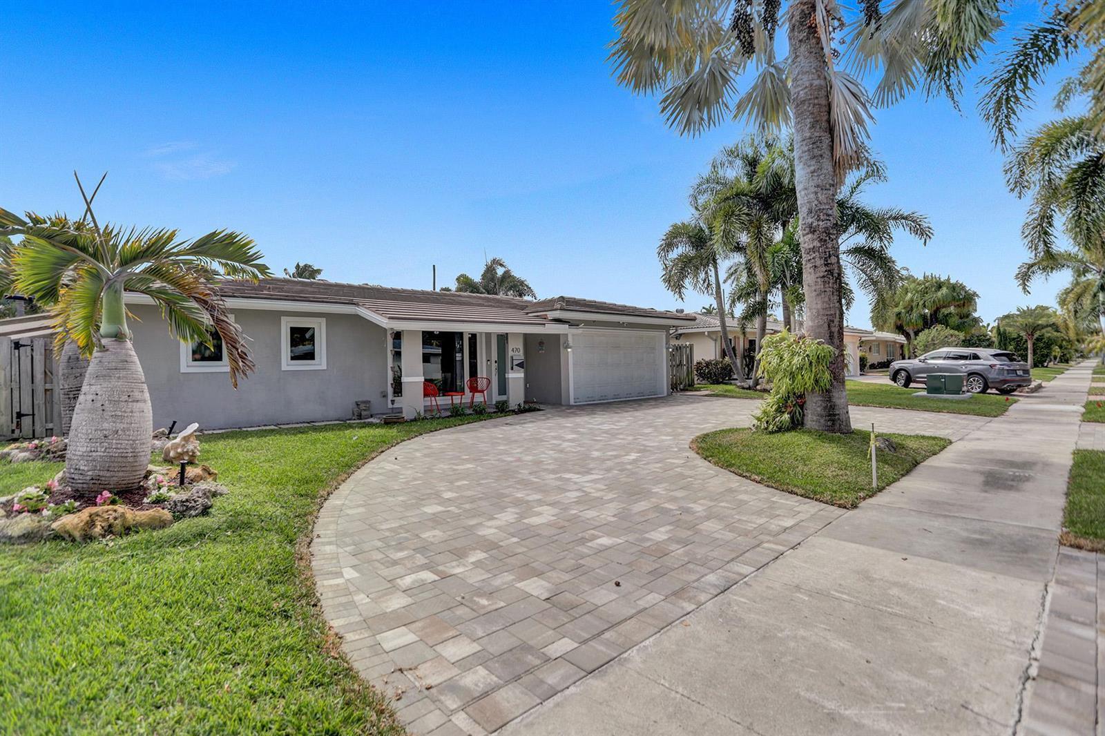 A single-story gray house features a paved driveway, a palm tree, and a two-car garage — 470 SE 4th Court, Pompano Beach FL 33060, POMPANO BEACH, FL