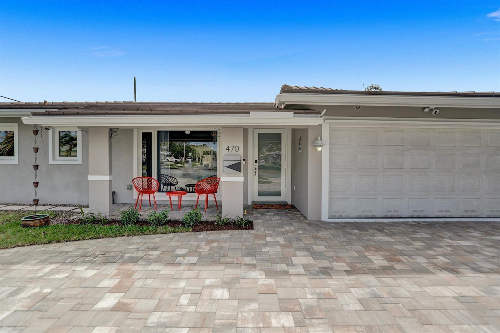 The exterior of a single-story house features a paved driveway, garage, and front patio area — 470 SE 4th Court, Pompano Beach FL 33060, POMPANO BEACH, FL