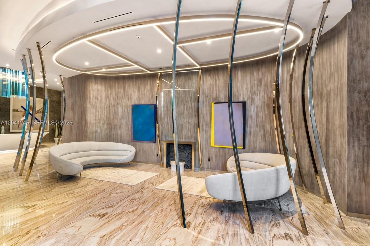 A modern lobby features curved white sofas, abstract art, and metallic room dividers — 1000 Brickell Plz # 2101, Miami FL 33131, MIAMI, FL