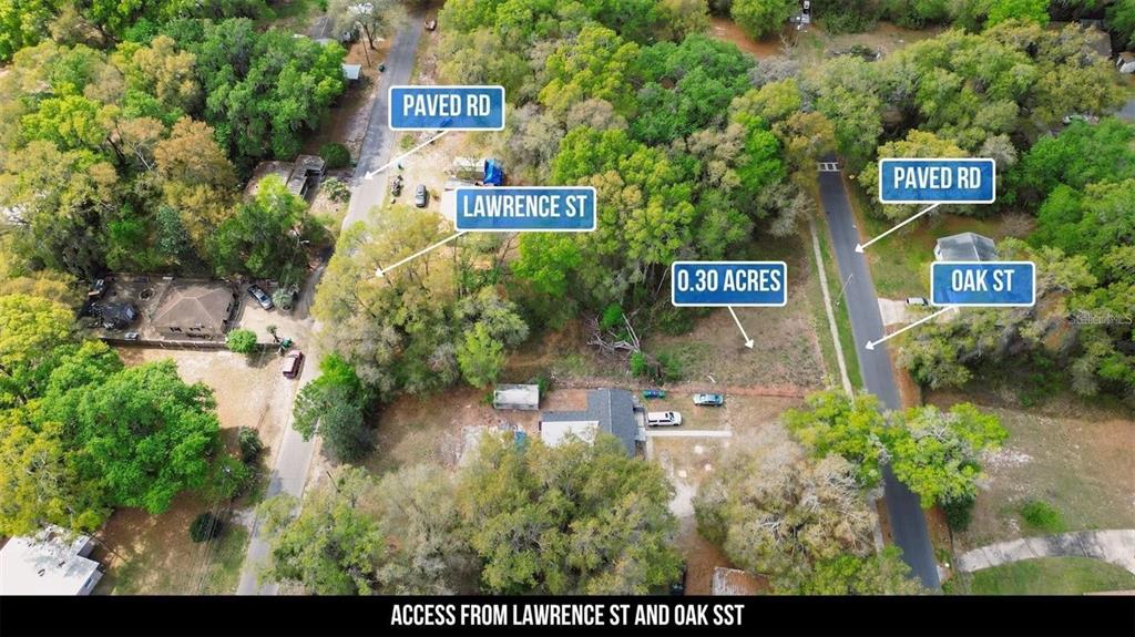 This aerial view shows a vacant 0.30-acre wooded lot bordered by two paved streets — LAWRENCE ST, WILDWOOD, FL