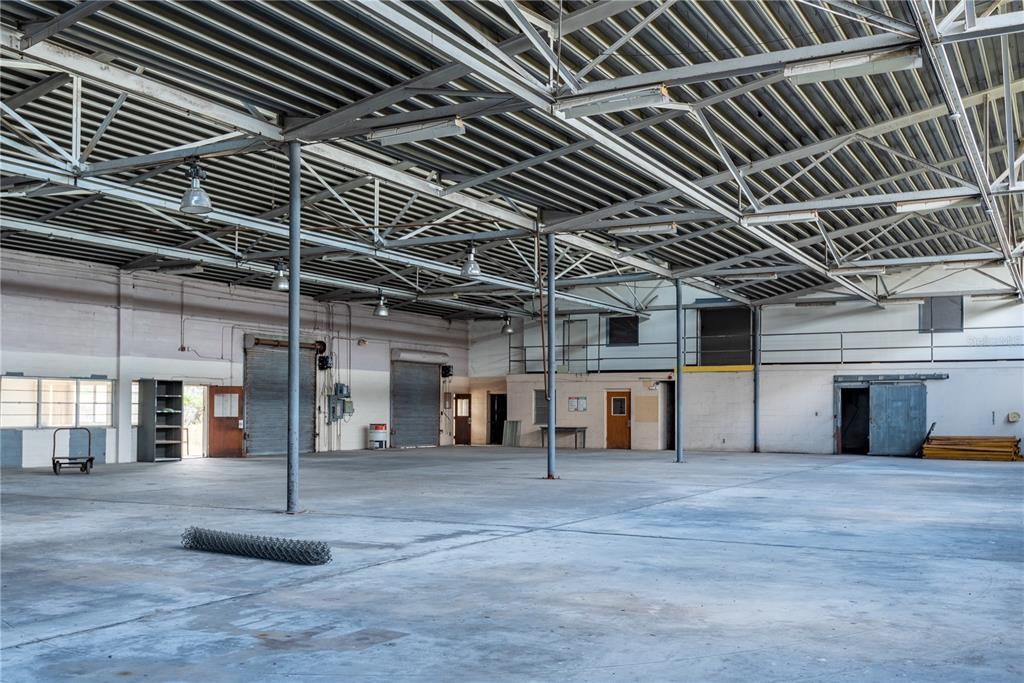 A large, empty industrial warehouse space features a high metal ceiling and concrete flooring — 5000 SE HWY 31 UNIT W, ARCADIA, FL