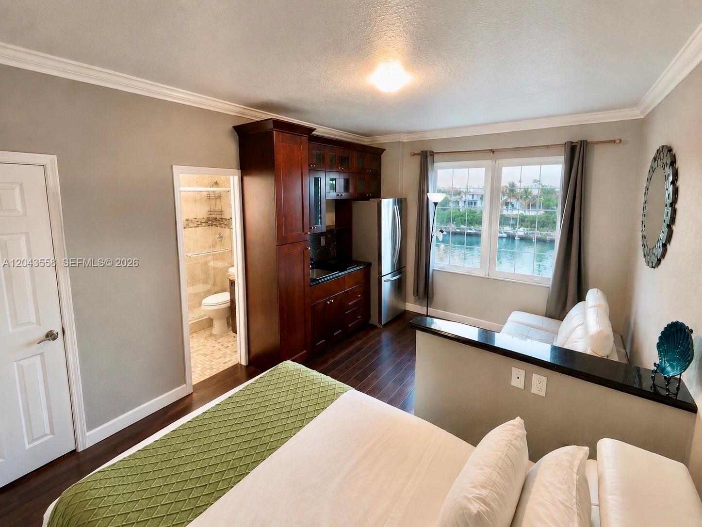 A studio bedroom features a kitchenette, a bathroom, and a view of the water — 3025 Indian Creek Dr # 320, Miami Beach FL 33140, MIAMI BEACH, FL