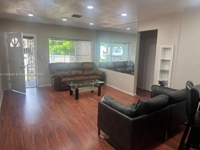 A living room features wood-look flooring, a brown leather sofa, and a glass coffee table — 740 NW 42nd St, Miami FL 33127, MIAMI, FL