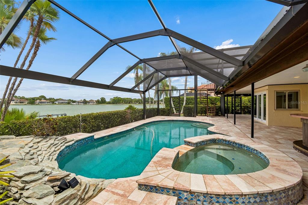 An aerial view of a waterfront house with a pool, screened lanai, and private dock — 9815 BAY ISLAND DRIVE, TAMPA, FL