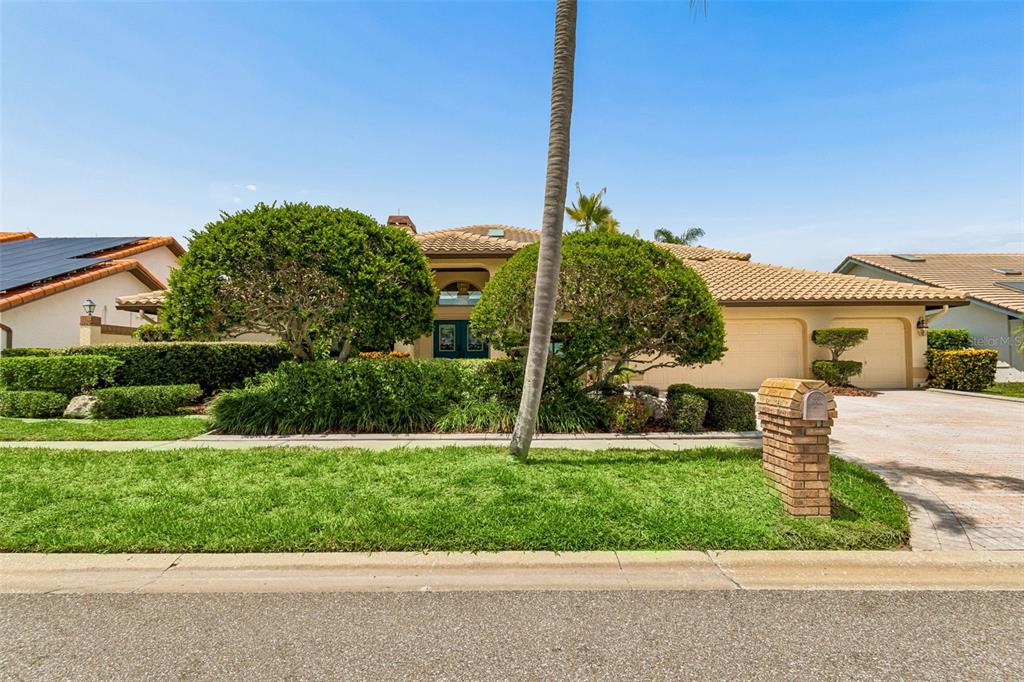 A single-story house with a tile roof, two-car garage, and manicured landscaping — 9815 BAY ISLAND DRIVE, TAMPA, FL