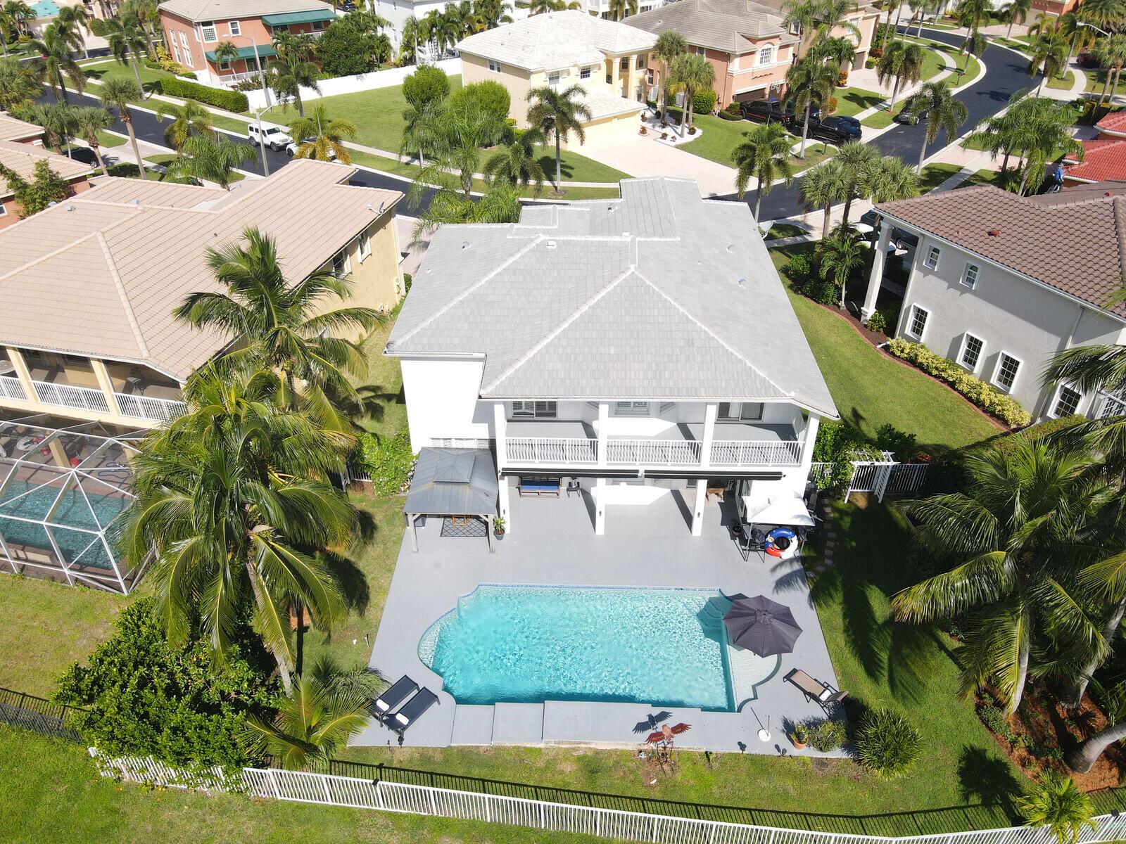 An aerial view of a white two-story house with a swimming pool and patio — 2176 Bellcrest Circle, Royal Palm Beach FL 33411, ROYAL PALM BEACH, FL