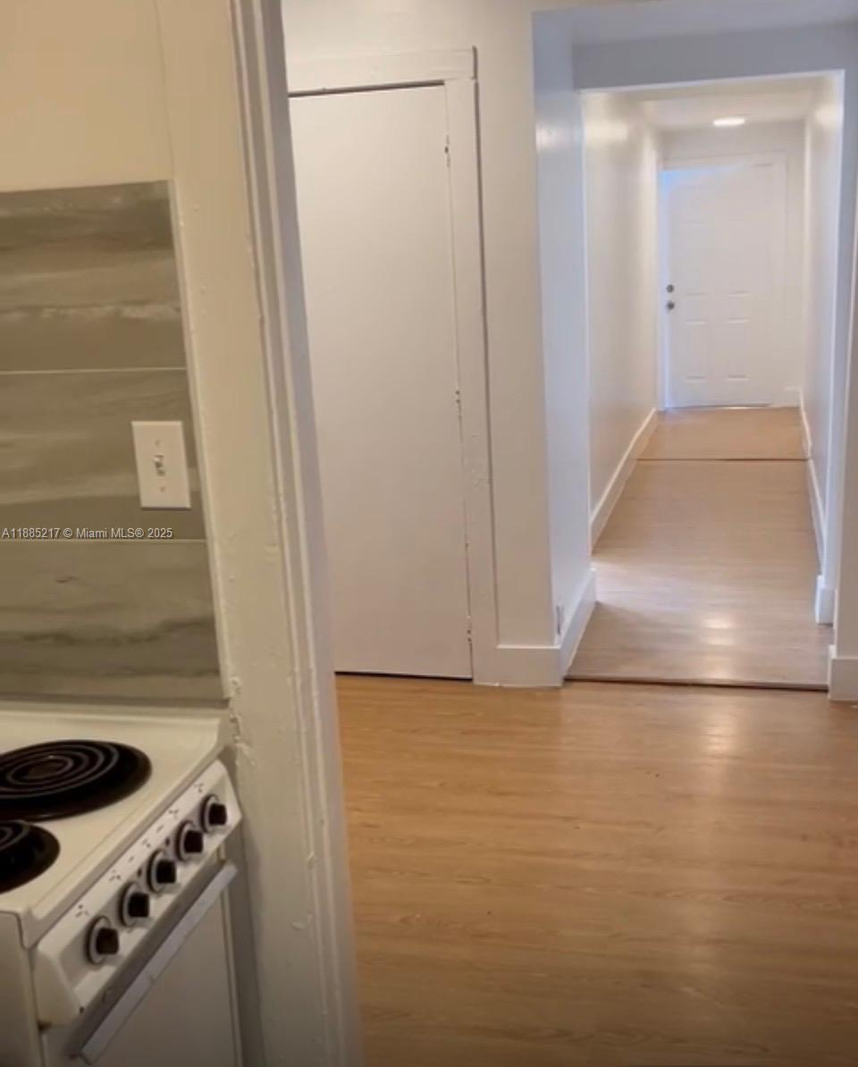 A view from a kitchen looking toward a hallway with light wood-style flooring — 506 18th St # B, West Palm Beach FL 33407, WEST PALM BEACH, FL