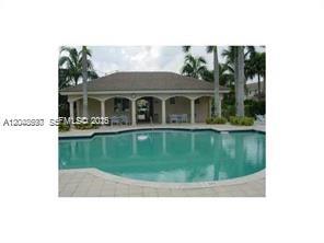 A swimming pool sits in front of a covered patio area with arched columns — 5779 NW 116 AV # 101, Doral FL 33178, DORAL, FL