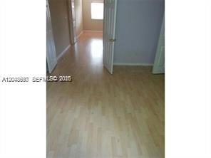 A room with light wood-look flooring and an open doorway leading to a hallway — 5779 NW 116 AV # 101, Doral FL 33178, DORAL, FL