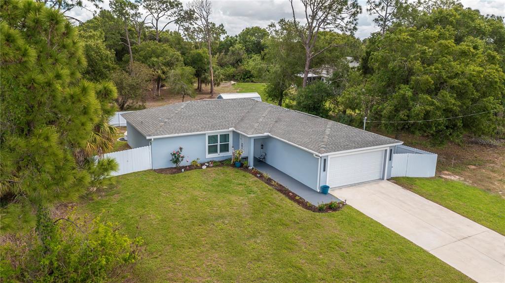 An aerial view of a light blue single-story house with a white garage and lawn — 7081 BRAZIL CIRCLE, LABELLE, FL