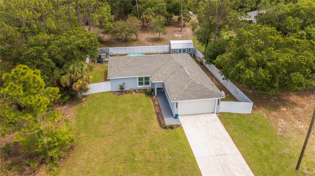 An aerial view of a single-story house with a garage, driveway, and fenced backyard — 7081 BRAZIL CIRCLE, LABELLE, FL