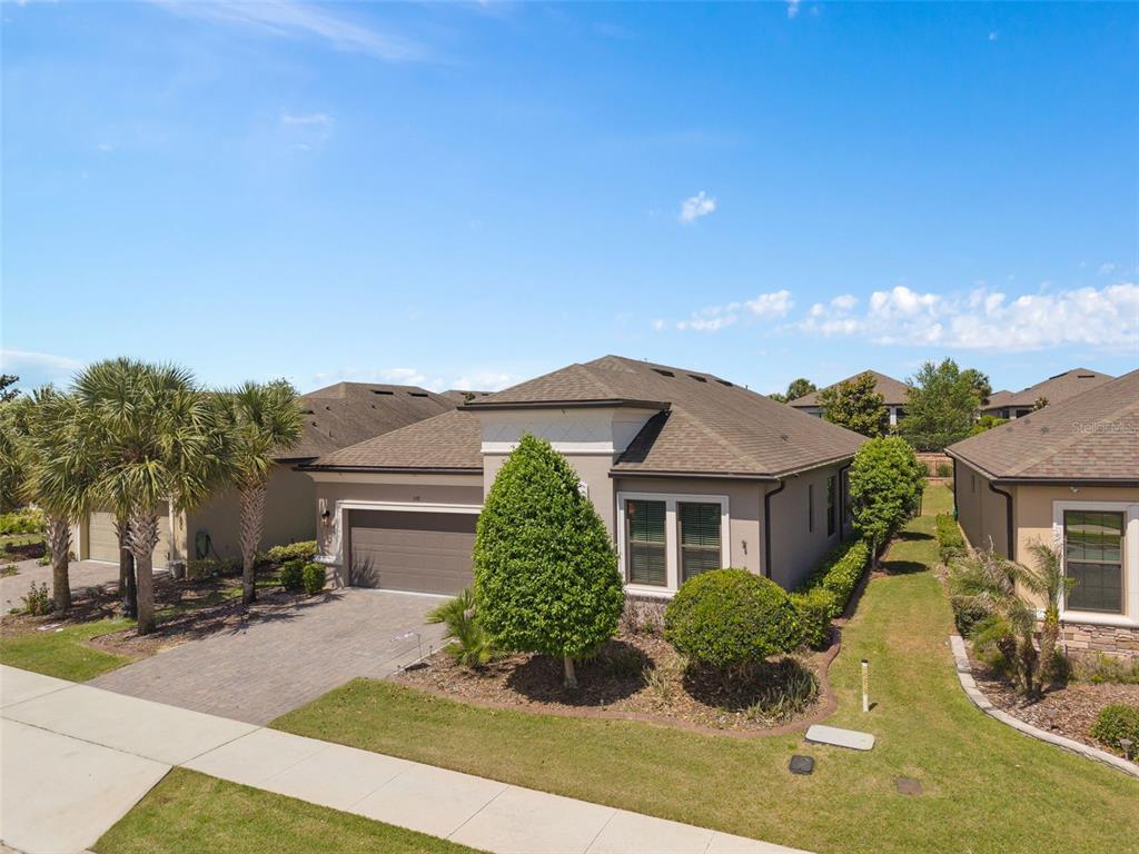 A single-story suburban house with a paved driveway, a two-car garage, and landscaped front yard — 1192 ESPERANZA RIDGE ROAD, CLERMONT, FL