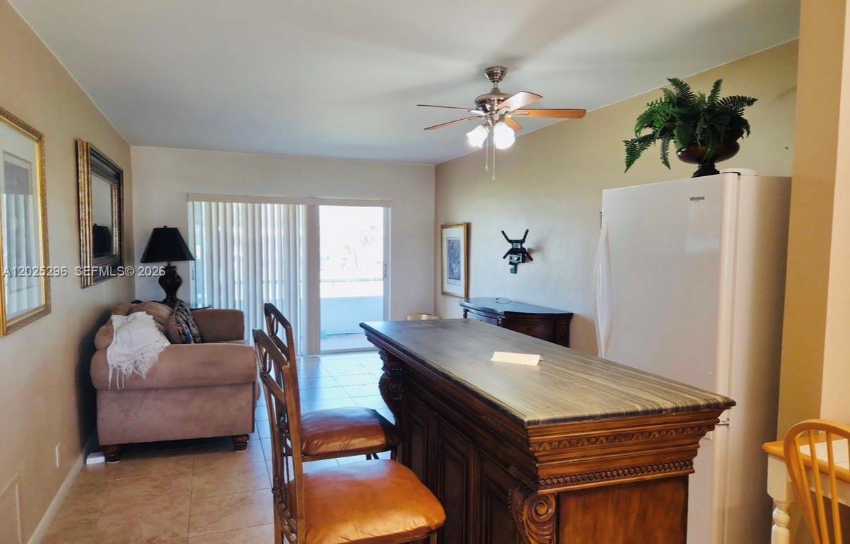 A living and dining area features a wooden bar, a sofa, and a ceiling fan — 251 S Golf Blvd # 289, Pompano Beach FL 33064, POMPANO BEACH, FL