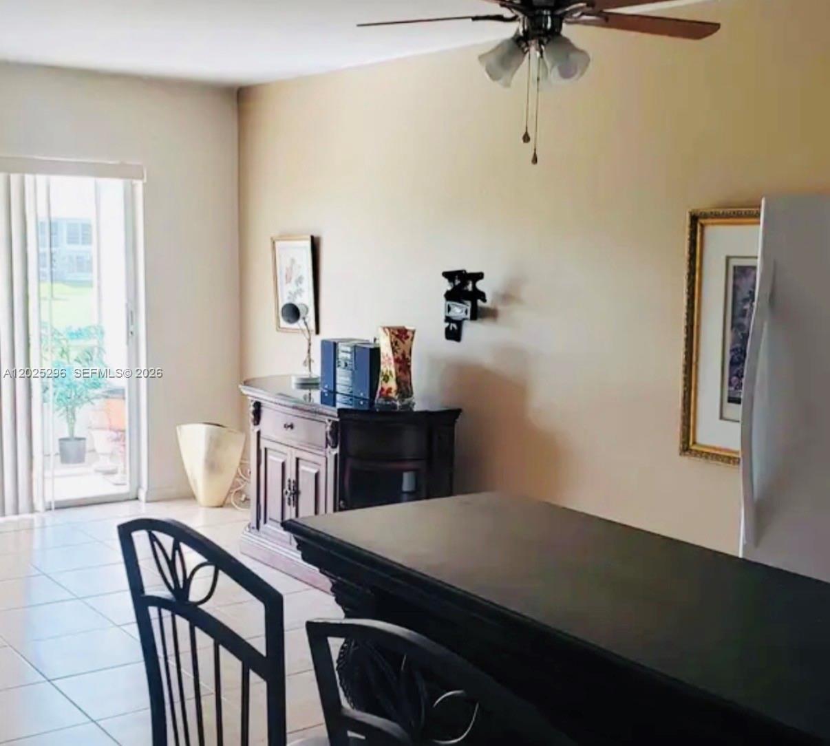 A dining area features a dark wood table, matching chairs, and a sideboard near a sliding door — 251 S Golf Blvd # 289, Pompano Beach FL 33064, POMPANO BEACH, FL