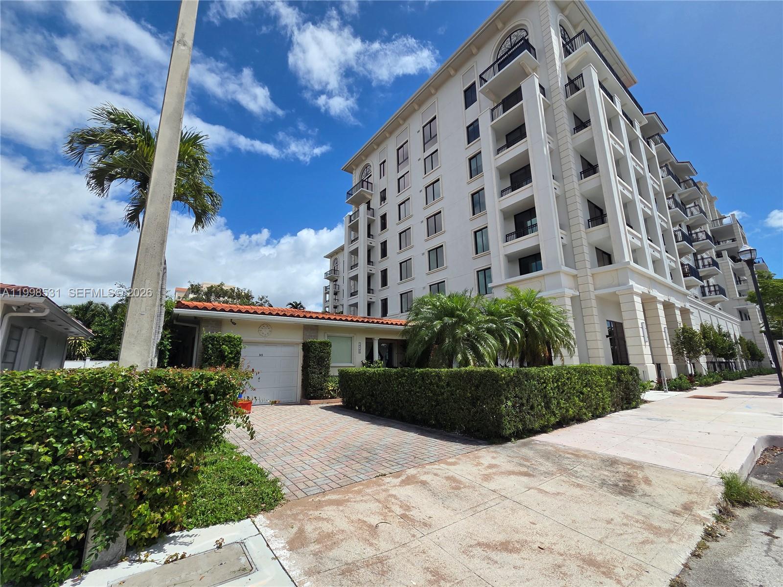 A multi-story white apartment building stands next to a single-story house with a garage — 345 Malaga Ave, Coral Gables FL 33134, CORAL GABLES, FL