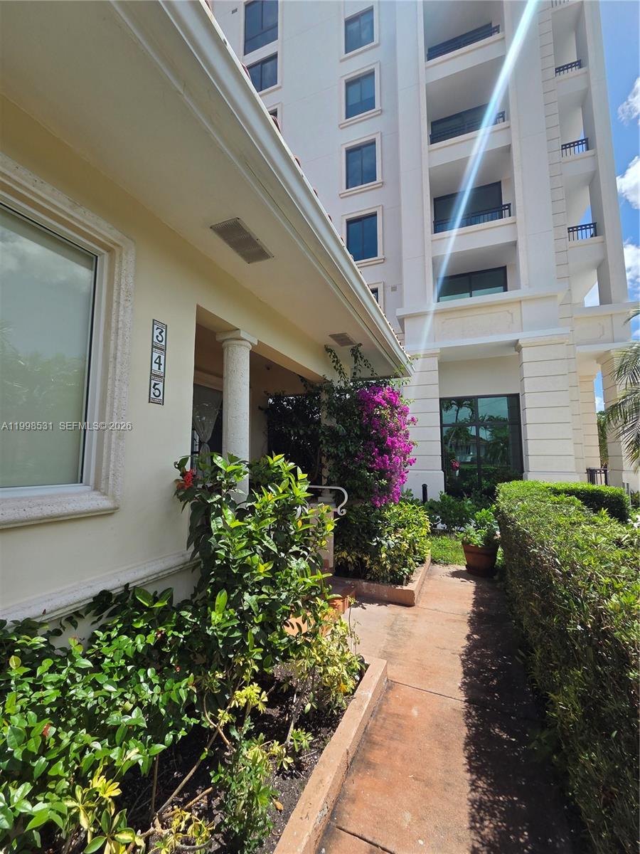 A walkway leads to a building entrance with a house number sign and landscaping — 345 Malaga Ave, Coral Gables FL 33134, CORAL GABLES, FL