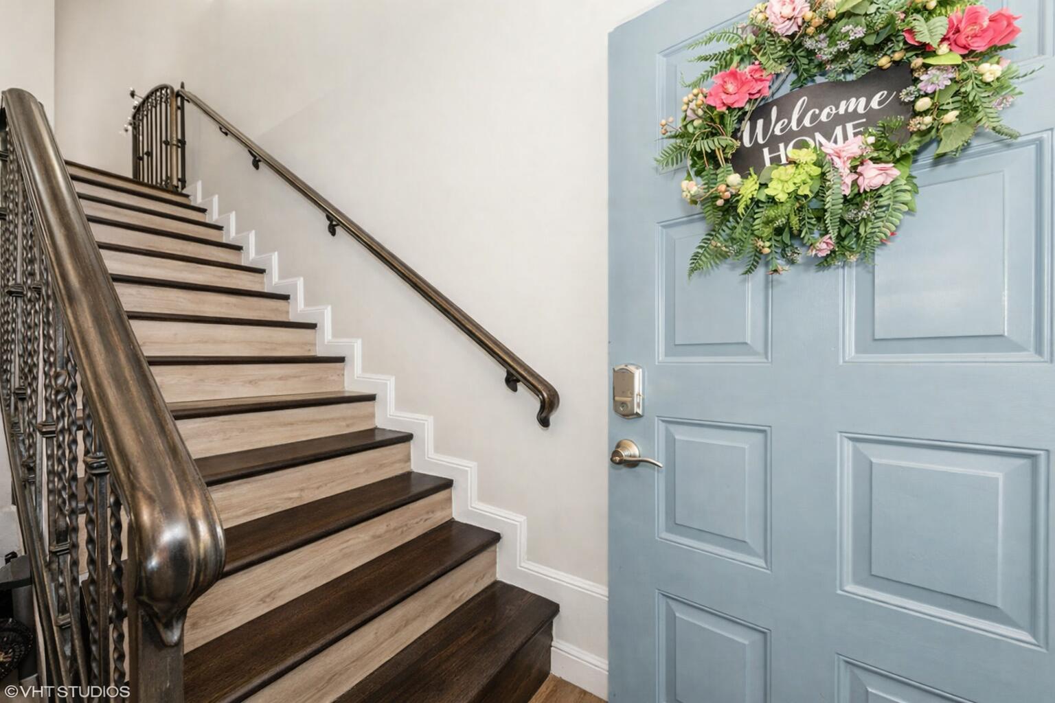 A blue front door with a floral wreath sits beside a staircase with wooden treads — 805 Harbour Pointe Way, FL 33413, FL