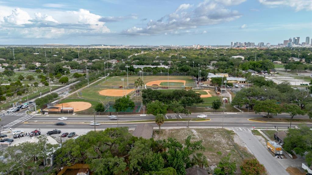 A vacant, grassy lot with a small building in the background under a cloudy sky — 2100 E DR MLK, TAMPA, FL