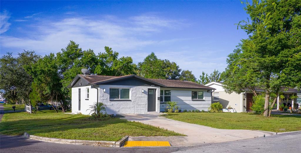 A single-story white brick house with a dark roof and a concrete driveway — 6400 MONTANA AVENUE, NEW PORT RICHEY, FL