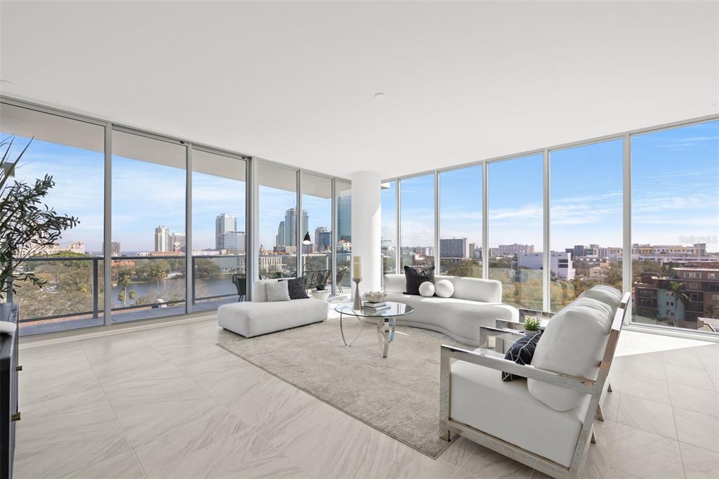 A modern living room with white furniture, large floor-to-ceiling windows, and a city skyline view — 777 3RD AVENUE N UNIT 805, ST PETERSBURG, FL