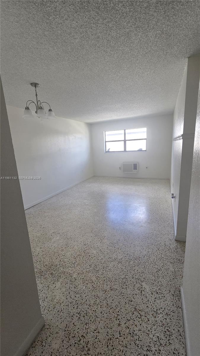 An empty room features white walls, a light-colored terrazzo floor, and a hanging light fixture — 142 SW 18th ave # 30, Miami FL 33135, MIAMI, FL