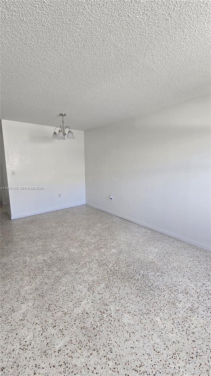 An empty room features white walls, a textured ceiling, and light-colored speckled terrazzo flooring — 142 SW 18th ave # 30, Miami FL 33135, MIAMI, FL