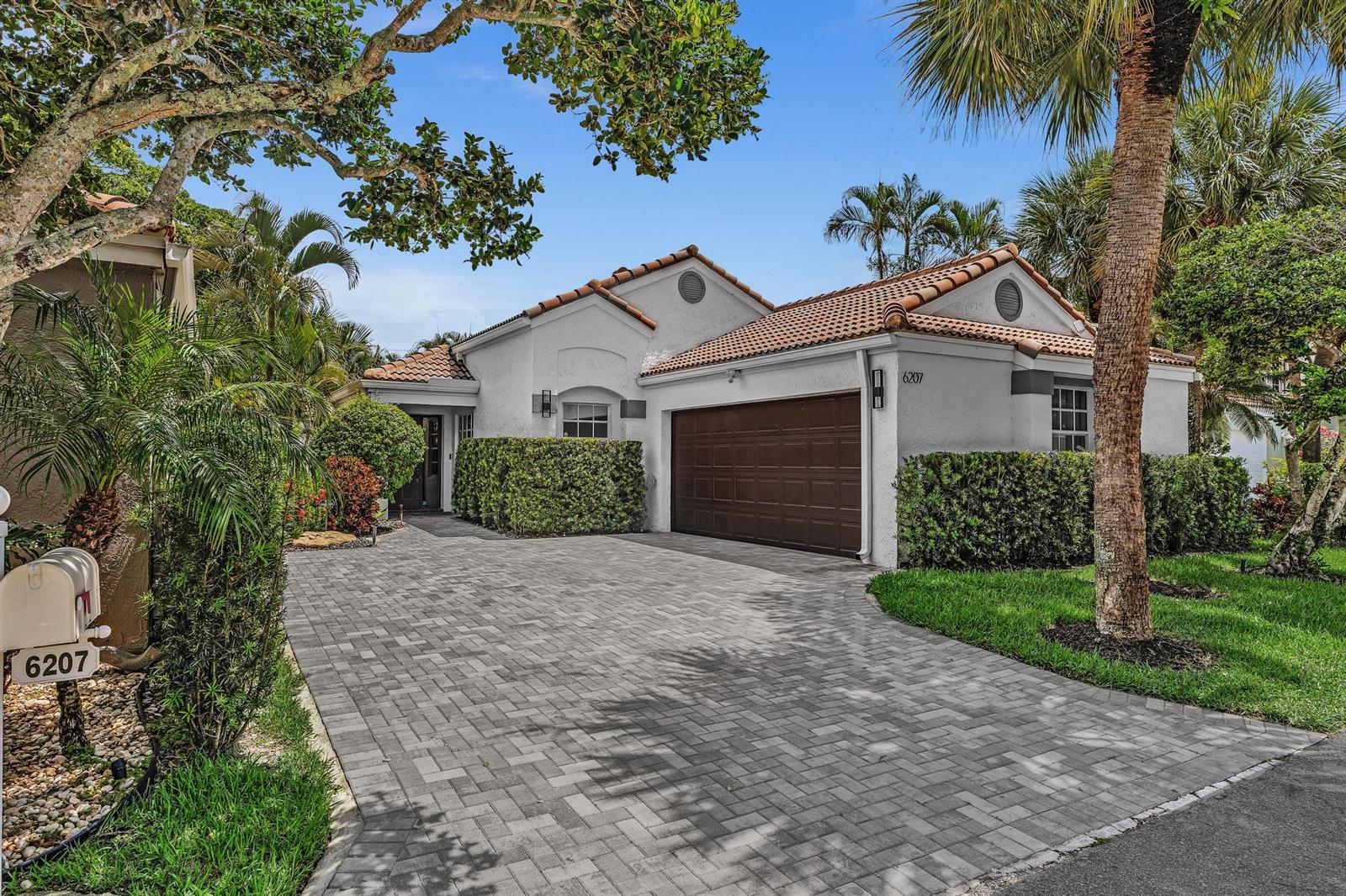 A single-story house with a white stucco exterior, a brown garage door, and a paved driveway — 6207 La Vida Terrace, Boca Raton FL 33433, BOCA RATON, FL