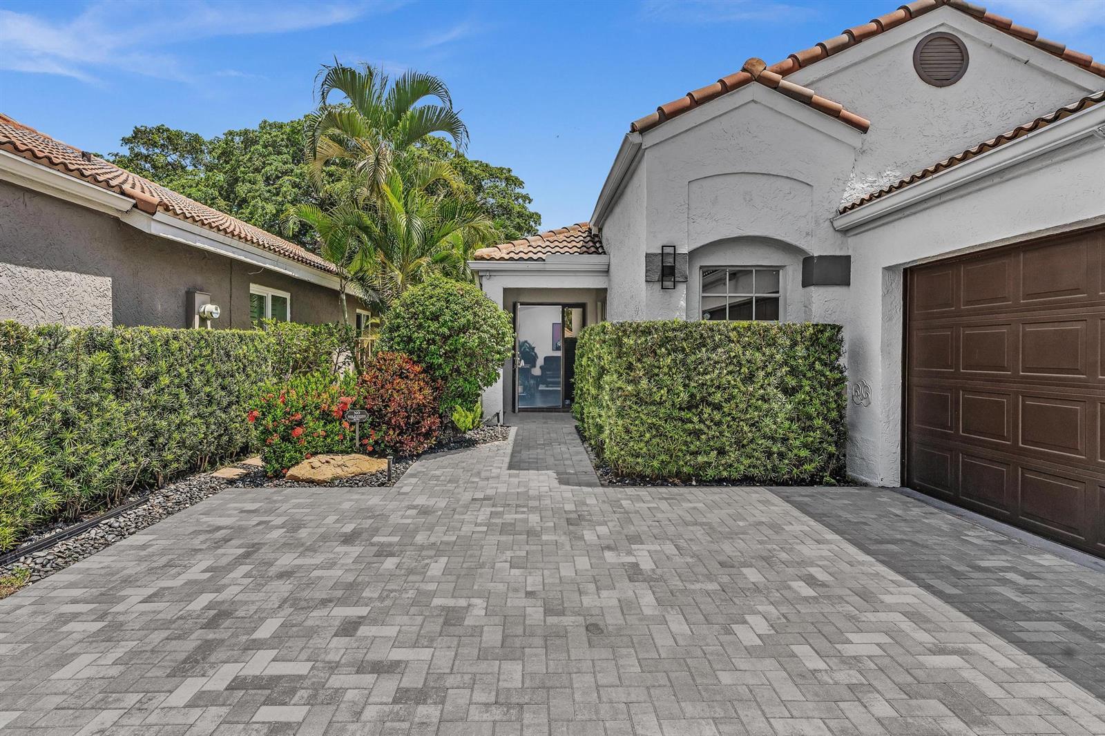 A paved driveway leads to the entrance of a house with a brown garage door — 6207 La Vida Terrace, Boca Raton FL 33433, BOCA RATON, FL