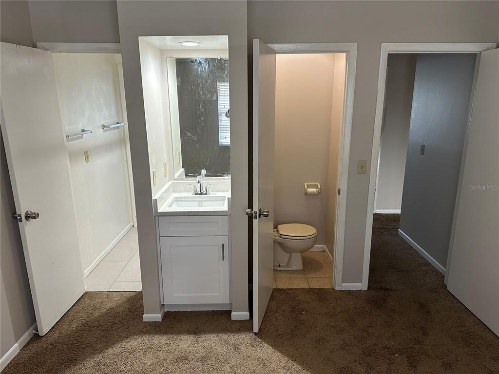 A bathroom vanity sits between a tiled shower area and a separate toilet room — 3544 KHAYYAM AVENUE, ORLANDO, FL