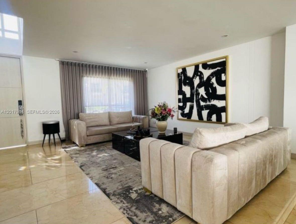 A living room features two beige sofas, a black coffee table, and abstract wall art — 20 ST Loma Montesori Poblado, CO, CO