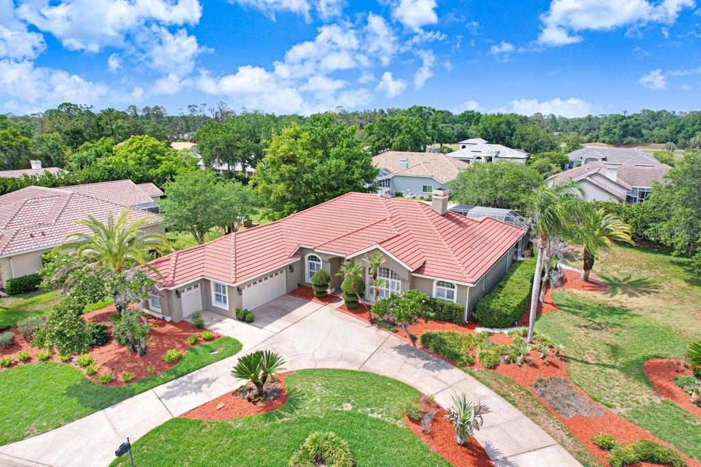 An aerial view of a single-story house with a red tile roof and circular driveway — 30303 LAURELWOOD LANE, WESLEY CHAPEL, FL