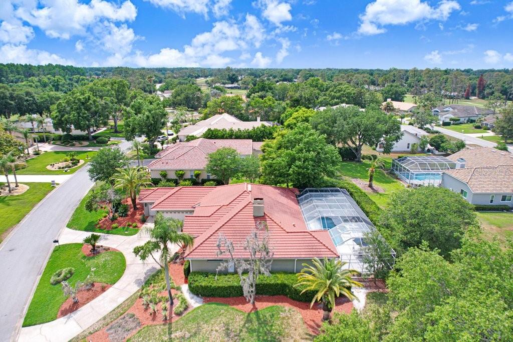 An aerial view of a single-story house with a red tile roof and screened pool — 30303 LAURELWOOD LANE, WESLEY CHAPEL, FL