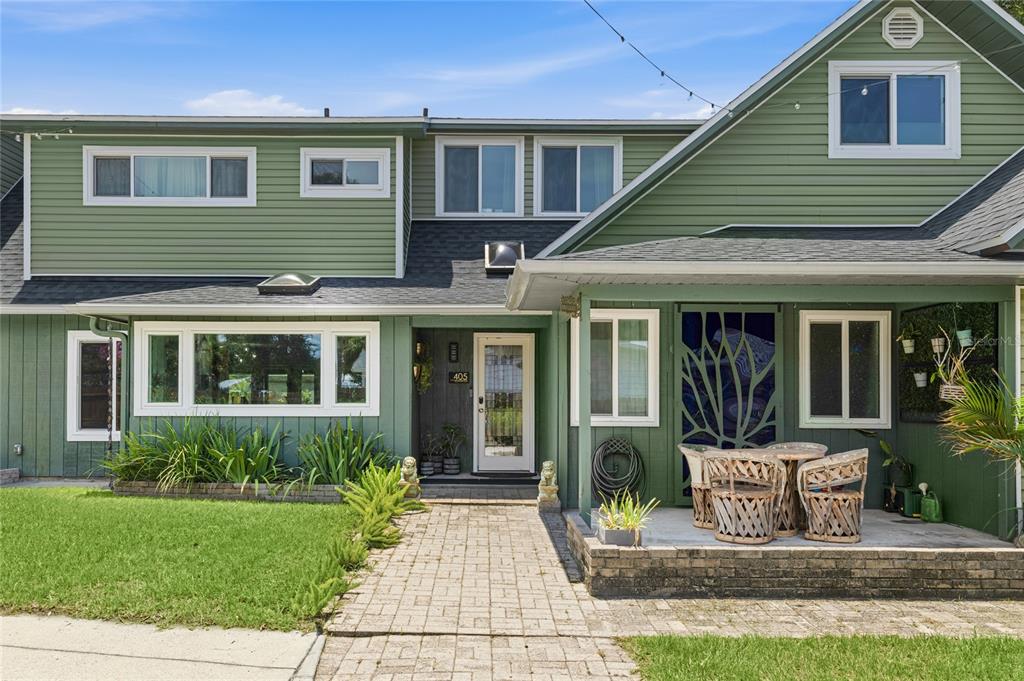 A two-story house with green siding, a brick walkway, and a covered front porch — 405 BAY POINT AVENUE, NOKOMIS, FL