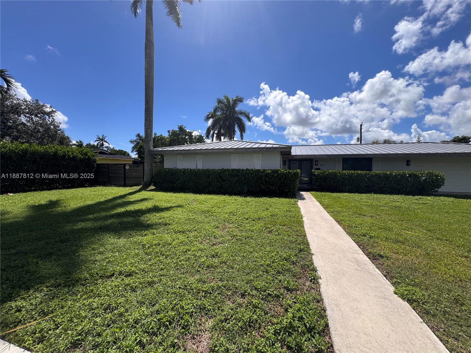A single-story house with a metal roof and a hedge-lined front yard — 444 NW 21st St, Homestead FL 33030, HOMESTEAD, FL