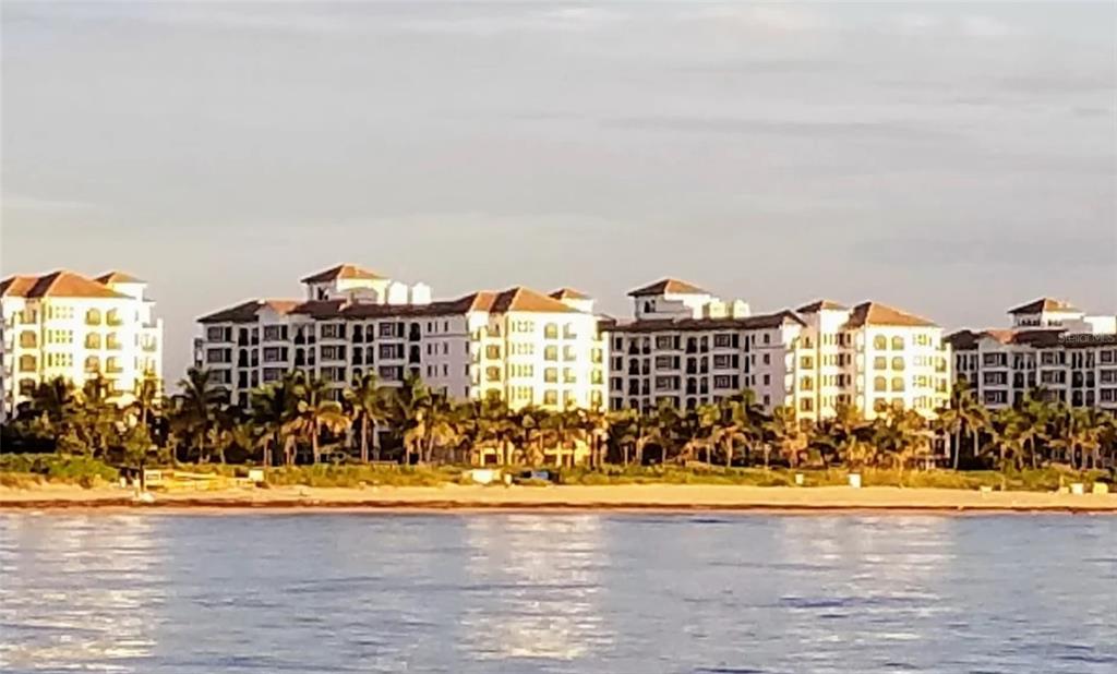 A row of multi-story white residential buildings stands behind a sandy beach and ocean — 71 S OCEAN AVENUE UNIT 8708, PALM BEACH SHORES, FL