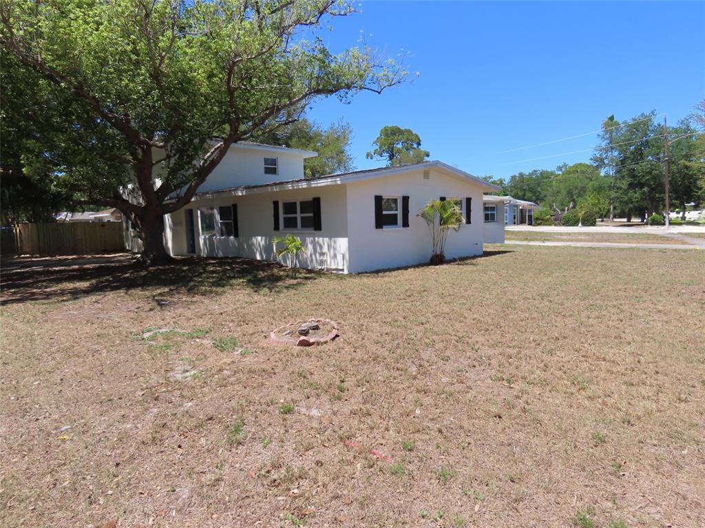 A white, two-story house with black shutters sits on a dry, grassy lot — 8055 33RD AVENUE N, ST PETERSBURG, FL